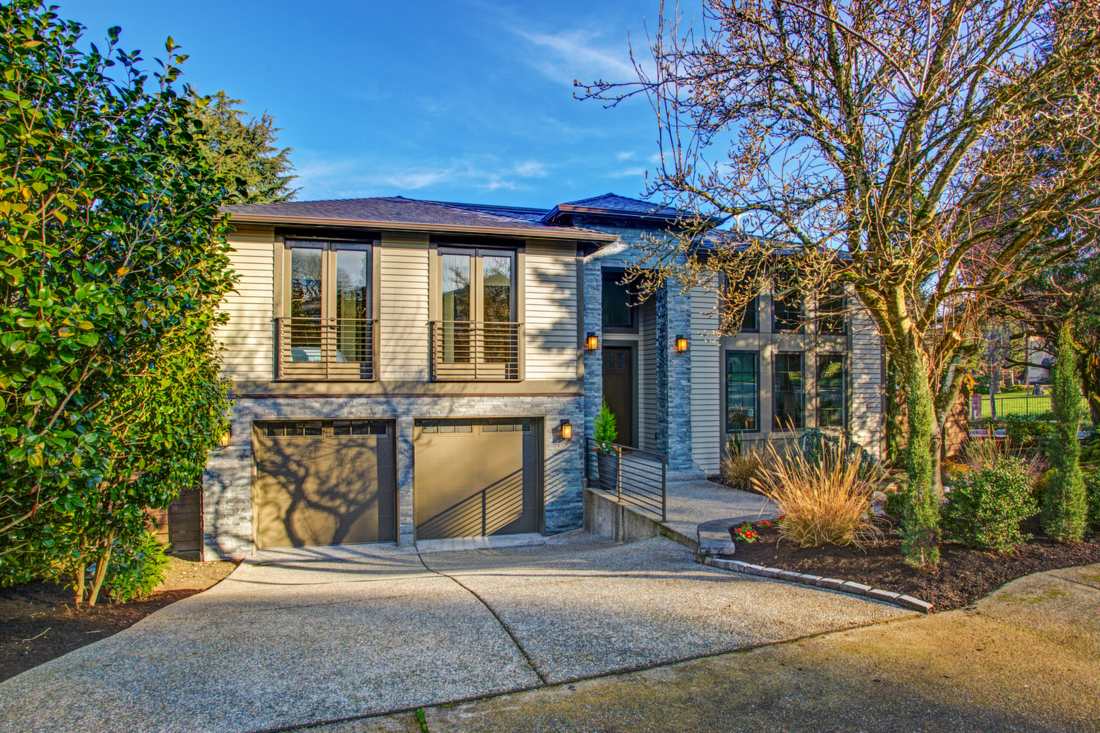 Compact two story home with large windows among trees and native plants, a setting that reflects DADU energy efficiency