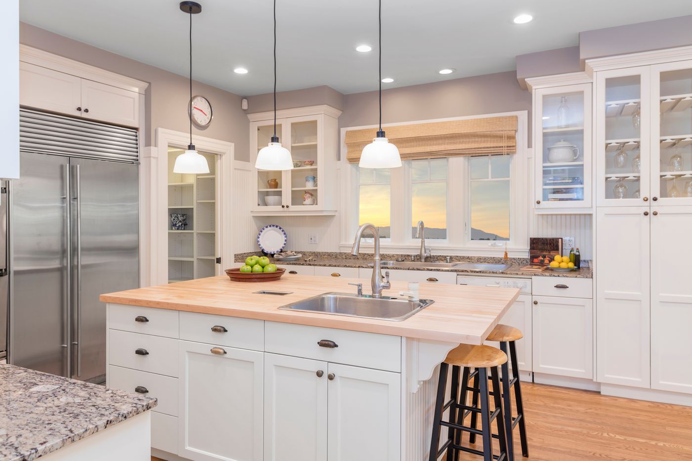 Bright finished kitchen with white cabinets and an island, the kind of space owners review at a DADU final walkthrough