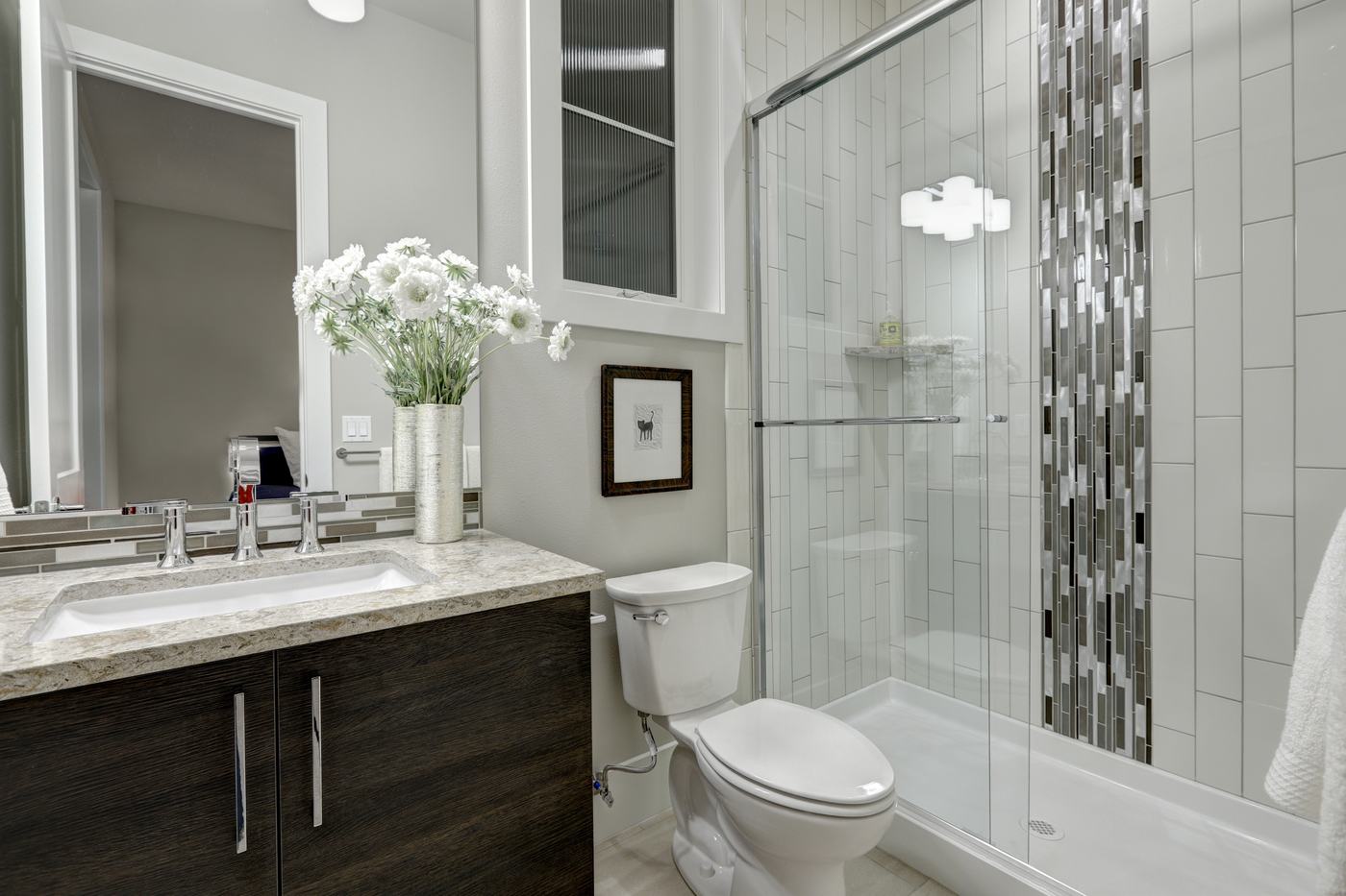 Modern bathroom with a glass walk in shower and vanity, where DADU water heaters supply daily hot water