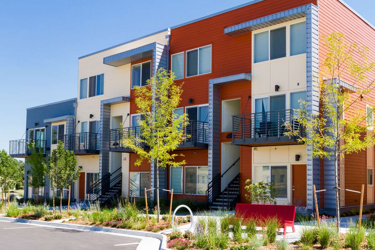 Seattle middle housing townhouses Modern three story townhouses with colorful siding and young street trees, a form of Seattle middle housing